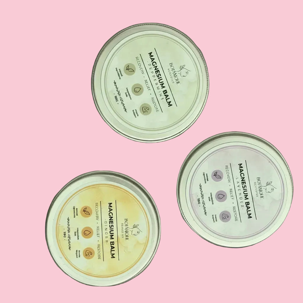 Three small containers of balm on a textured surface